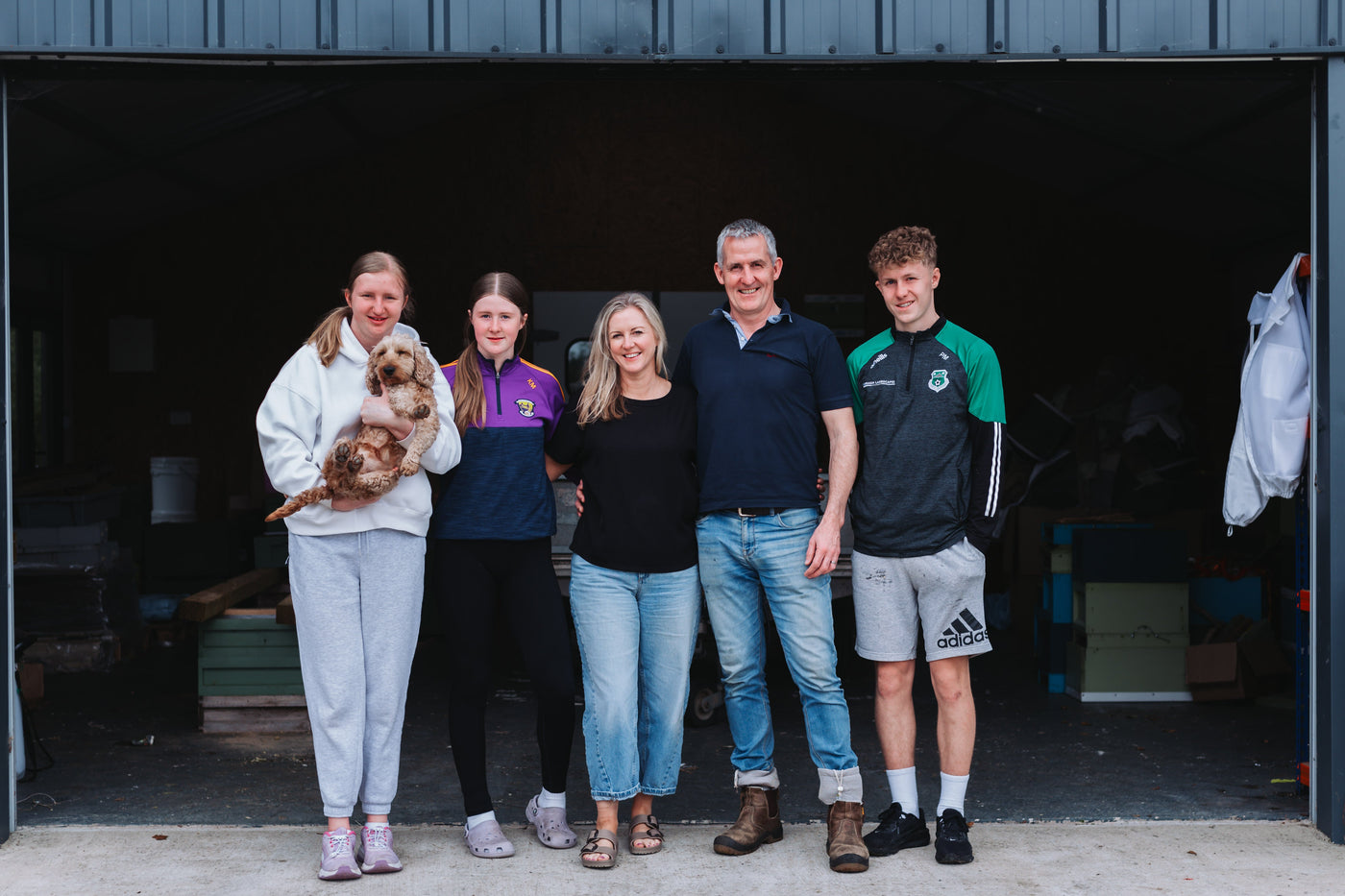 Family of five with two dogs standing in front of a garage door.