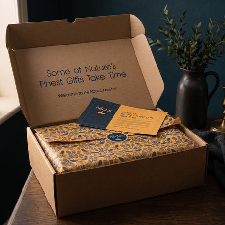 The Beekeeper hamper opened, gold tissue sealed with a story card on top